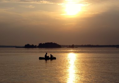 twee in een boot op zonsondergang achtergrond
