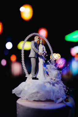 Düğün yeri - yeşil ve mor restoran salonu, neon ışıklı, beyaz üç katlı pasta.