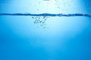 Mavi arka planda su şişesi düşüyor, damlalar düşüyor ve sıçrıyor. Su kabarcıkları dokusu