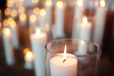 White candles background - burning out of focus fire