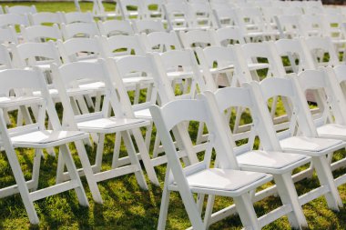 Multiple white folding chairs for event. Outdoor city wedding.