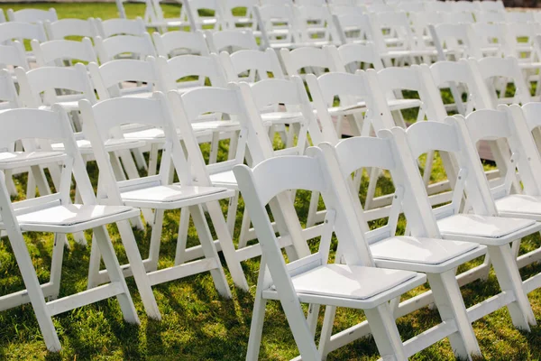 Multiple white folding chairs for event. Outdoor city wedding.