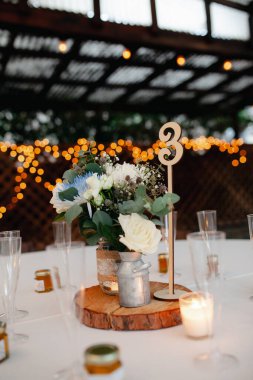 Sweethearts table - wooden rustic table with beautiful florals.  White roses, blue and purple chrysanthemum, eucalyptus leaves, baby breaths floral arrangement