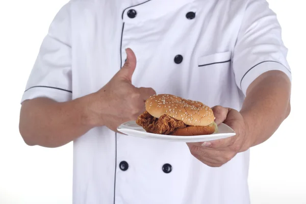 Hamburger on plate in hand of chef — Stock Photo, Image