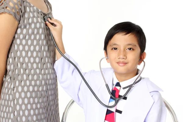 Мальчик в роли врача, осматривающего девочку — стоковое фото