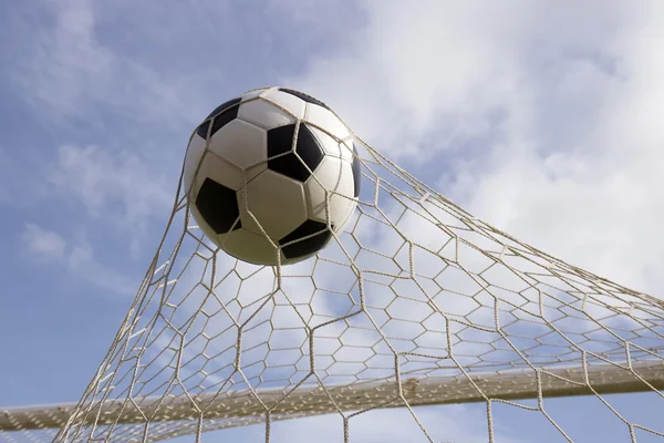 Bola de futebol no gol líquido — Fotografia de Stock
