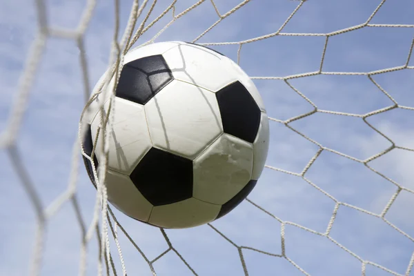 Pelota de fútbol en la red de goles — Foto de Stock