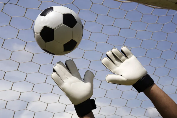 Mãos de goleiro atingindo bola pé — Fotografia de Stock