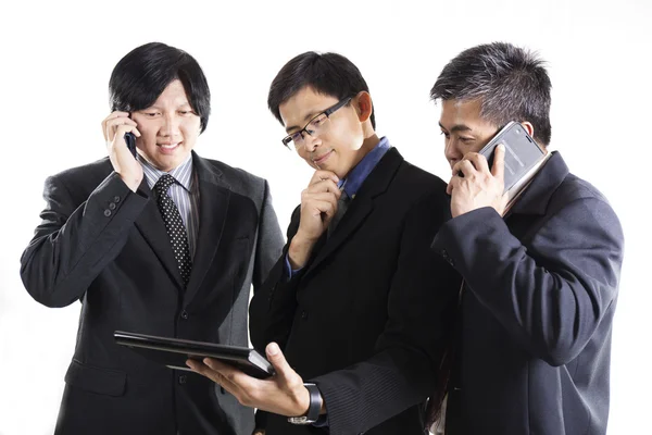 Três empresários que se reúnem e usam celular — Fotografia de Stock