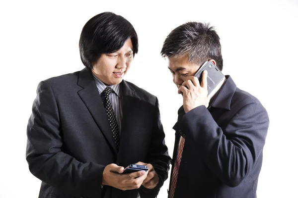 Dos hombres de negocios reunión y utiliza el teléfono móvil —  Fotos de Stock