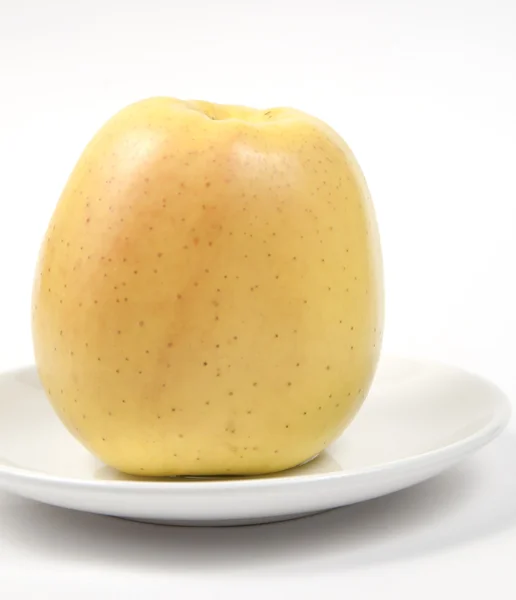 Pink apple on a white dish — Stock Photo, Image