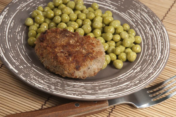Cutlet with green peas — Stock Photo, Image