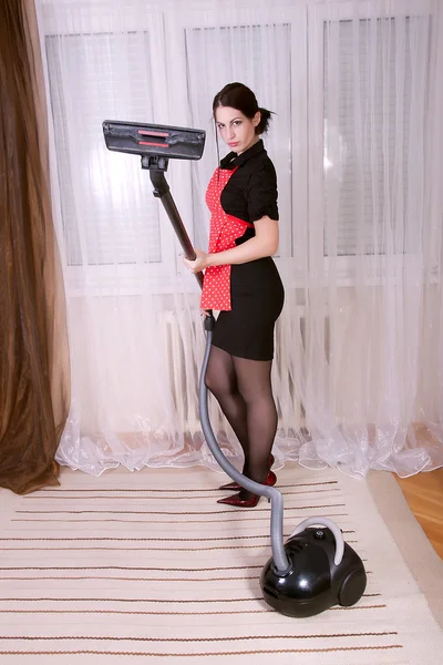 Beautiful young housewife with vacuum cleaner
