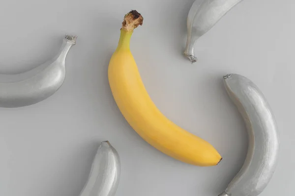 灰色の背景に灰色と黄色のバナナとパターン 夏の果物の概念 熱帯やエキゾチックなテクスチャ — ストック写真