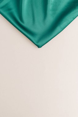 Bej arka planda yeşil ipekten yapılmış arka plan. Minimum moda ya da tatil şablonu. Boşluğu kopyala.