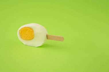 Yeşil arka planda dondurmalı yeni kesilmiş Paskalya yumurtası. Yaratıcı yemek ya da tatil konsepti.