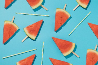 Taze karpuzlu dondurma ve açık mavi arka planda renkli pipetlerle moda. Asgari yaz partisi duvar kağıdı.