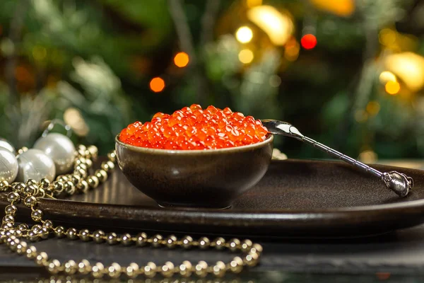 Červený kaviár v keramické misce, stříbrné korálky a perly na stříbrném podnose. Vánoce a Nový rok pozadí Royalty Free Stock Obrázky