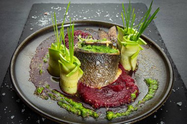 Dilimlenmiş kabak ve kırmızı pancar püresi ile süslenmiş balık rulosu. Asıl sunum