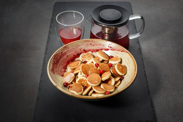 Dutch mini pancakes called poffertjes with red berries and tea. front view — Stock Photo, Image