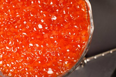 Red caviar in a glass bowl, micro lense, front view