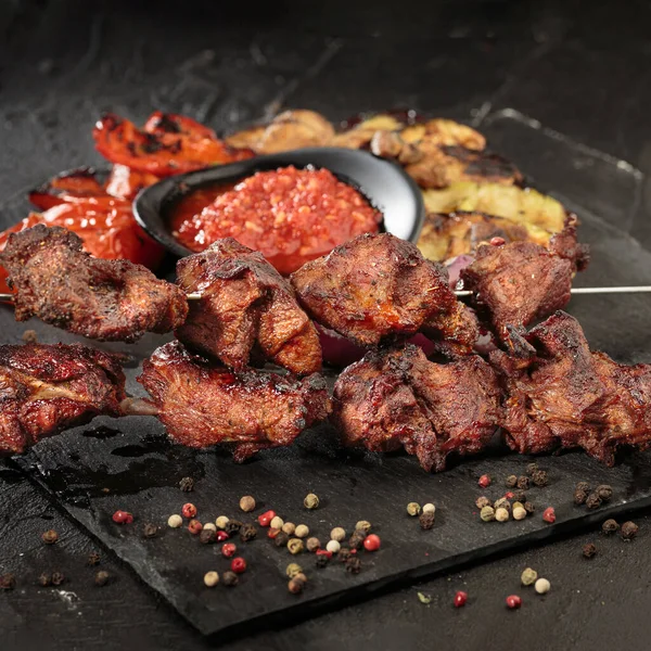 Shashlik ou shish kebab preparando-se em churrasqueira sobre carvão quente. Pedaços grelhados de carne de porco em espetos metálicos. Imagem quadrada — Fotografia de Stock