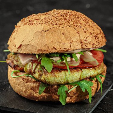 Köfteli, peynirli, sebzeli ve rukkola soslu ızgara burger. Kare resim