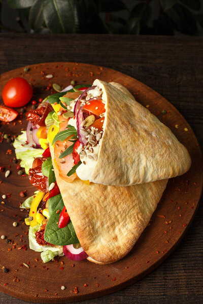 Doner kebab or pita on a wooden tray.