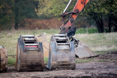 Kazı makinesi kovası yerde. İnşaat alanı ve yol inşaatı için kazı çalışması. İnşaat makineleri.