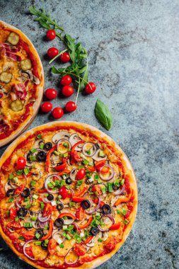 En üstte düz manzaralı pizzalar, arka planda taze ekolojik katmanlar, pizza tezgahı.