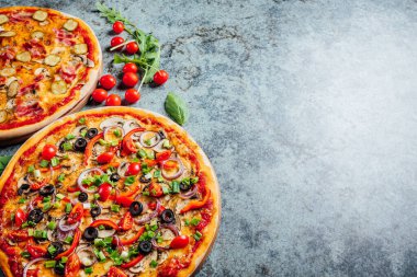 En üstte düz manzaralı pizzalar, arka planda taze ekolojik katmanlar, pizza tezgahı.