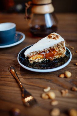 Ahşap arka planda fındıklı, fındıklı karamel kek, kahve dükkanı foo