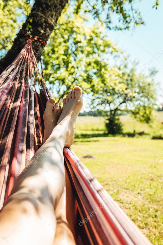 Man relaxing in hammok, man is lying in the hammok and chilling, man feets