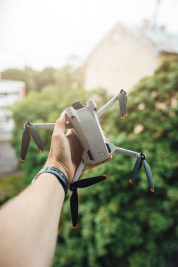 Man hand holding a small light drone, drone pilot with a drone