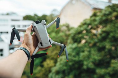 Man hand holding a small light drone, drone pilot with a drone