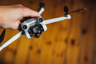 Man hand holding a small light drone, drone pilot with a drone