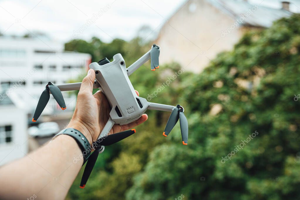Man hand holding a small light drone, drone pilot with a drone