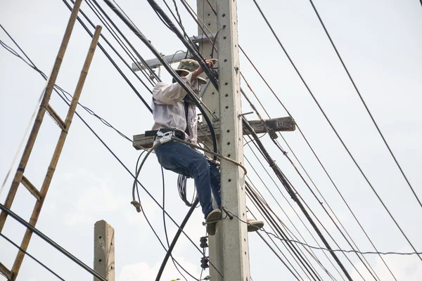 Electricista lineman reparador de trabajo en trabajos de escalada en poste eléctrico poste de energía —  Fotos de Stock