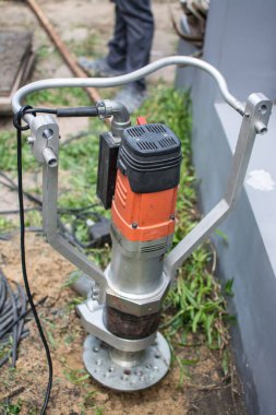 İşçi ev inşa etmek için vida yığını temelini büker