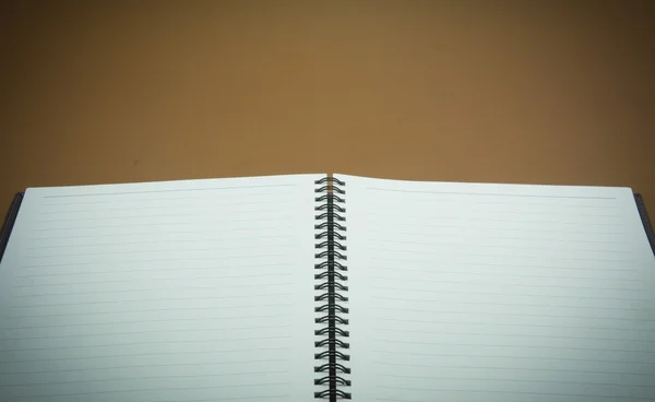 Notebook na hnědé pozadí — Stock fotografie