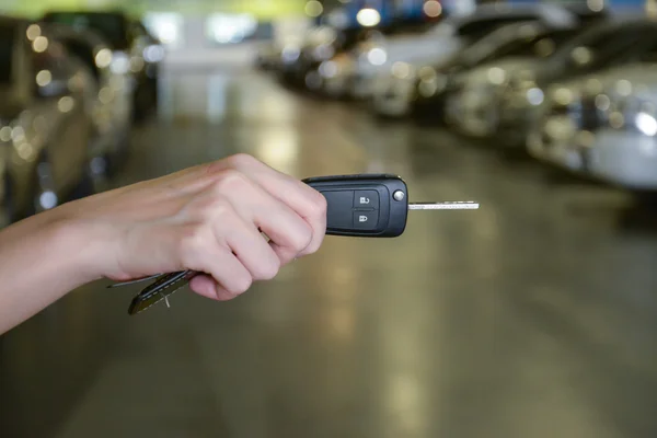 Main avec une clé de voiture dans le parking — Photo