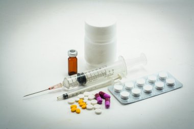 Hap hap şişesi ve üzerinde beyaz izole şırınga dışarı dökülmesini