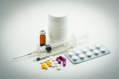 Hap hap şişesi ve üzerinde beyaz izole şırınga dışarı dökülmesini