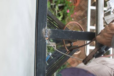 İşçi inşaat alanındaki çatının çelik yapısını kaynaklıyor..