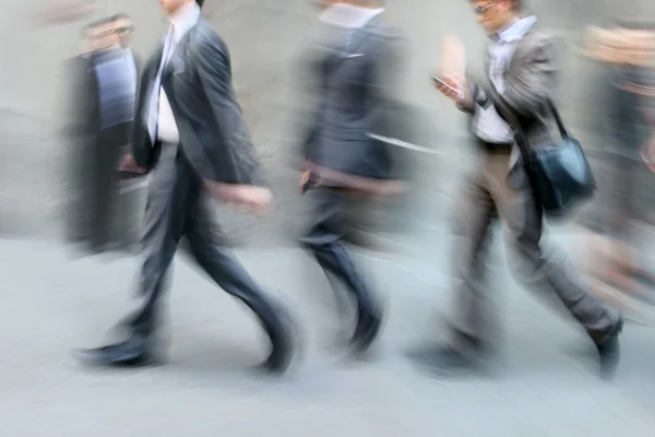 Motion blurred business people walking on the street — Stock Photo, Image