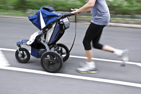 Moeder met haar baby in een wandelwagen — Stockfoto