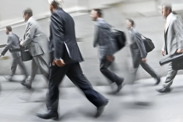 Motion blurred business people walking on the street — Stock Photo, Image