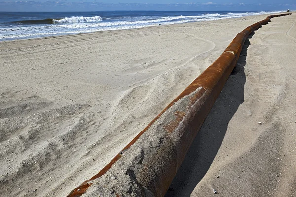 Rusty pipes along the sea beach — Stock Photo, Image