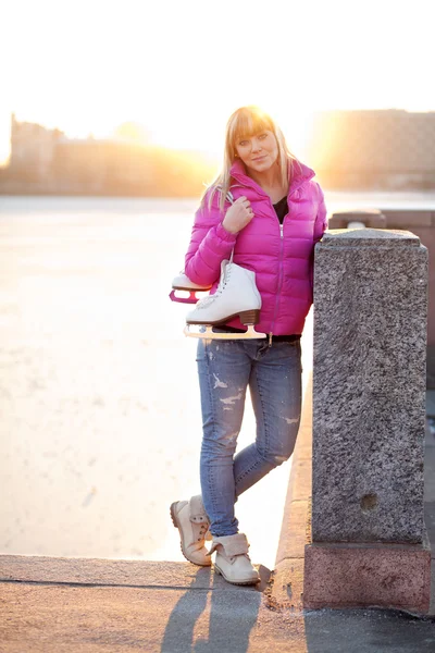 Blond woman standing with ice skates — Stock Photo, Image