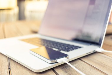 bir dizüstü bilgisayar tarafından tahsil ediliyor smartphone